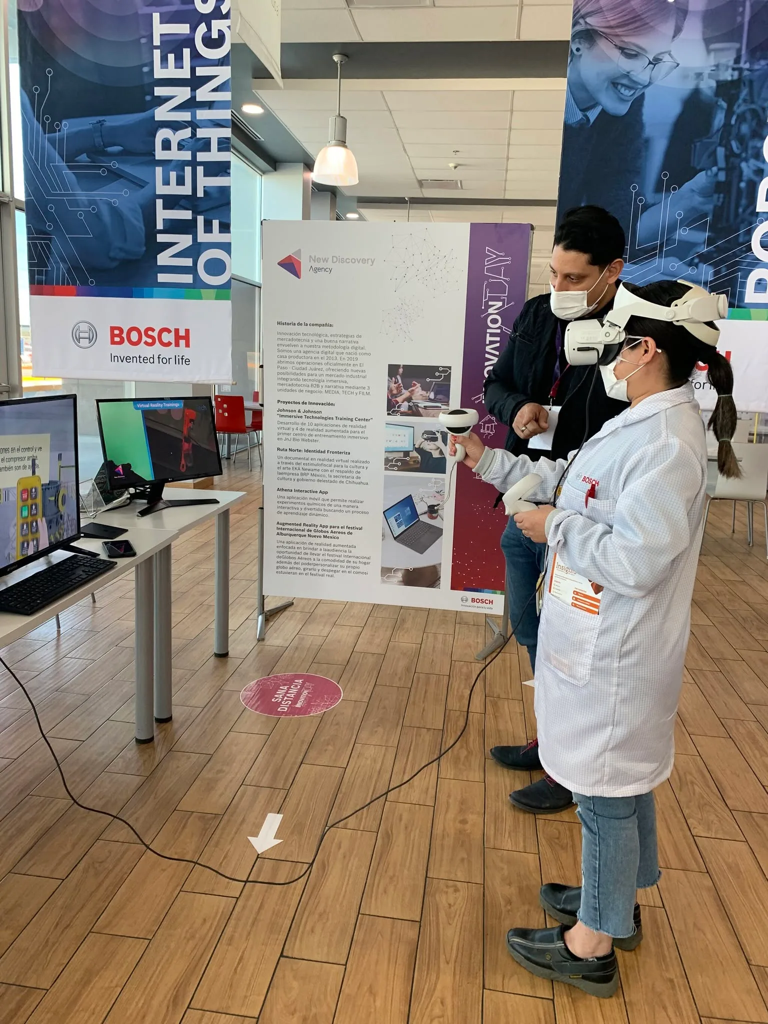 Una visitante en bata de laboratorio probando una aplicación de realidad virtual en el stand de New Discovery, Bosch Innovation Day